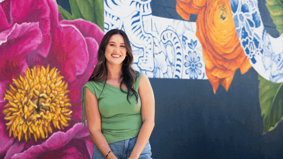 Photos of a vibrant, floral-themed mural on a large navy blue wall, with the word "BLOOM" on it.