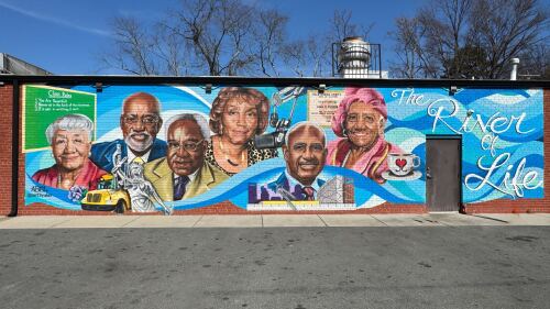 A street wall painted depicting prominent local African American figures in Charlotte.