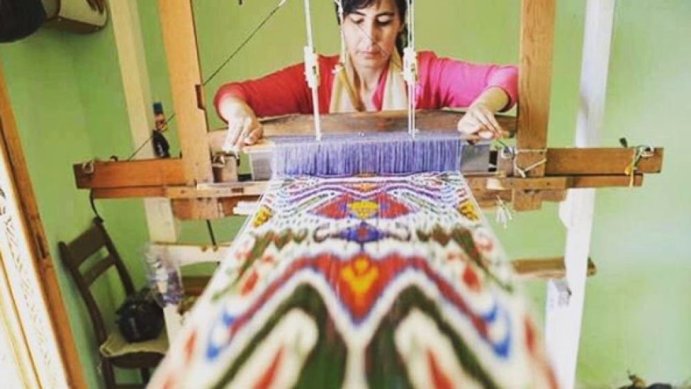woman threading together apparel for Ibu