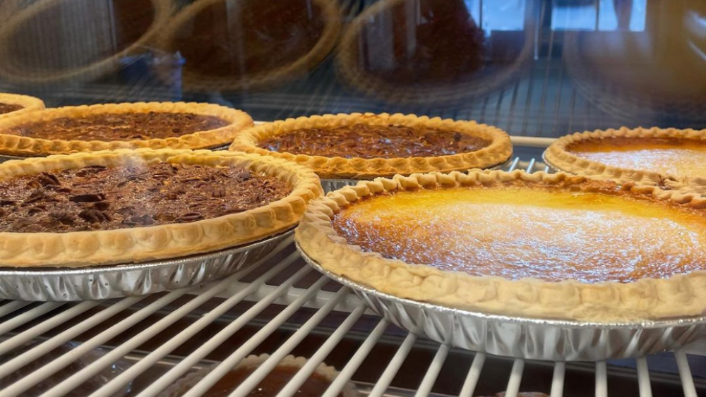Five pecan and pumpkin pies in a display case at Reececliff Diner