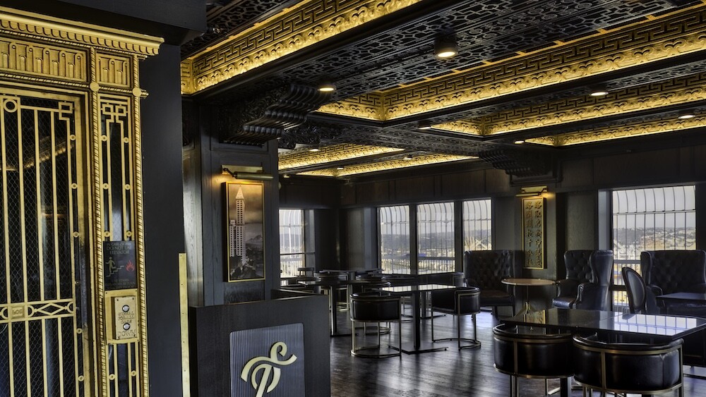The Smith Tower Observatory Bar with gilded accents on the ceiling and dark wood on the furniture and floors.