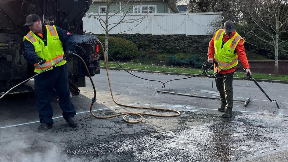 The Portland Bureau of Transportation's pothole repair crew works on a large patch in the street.