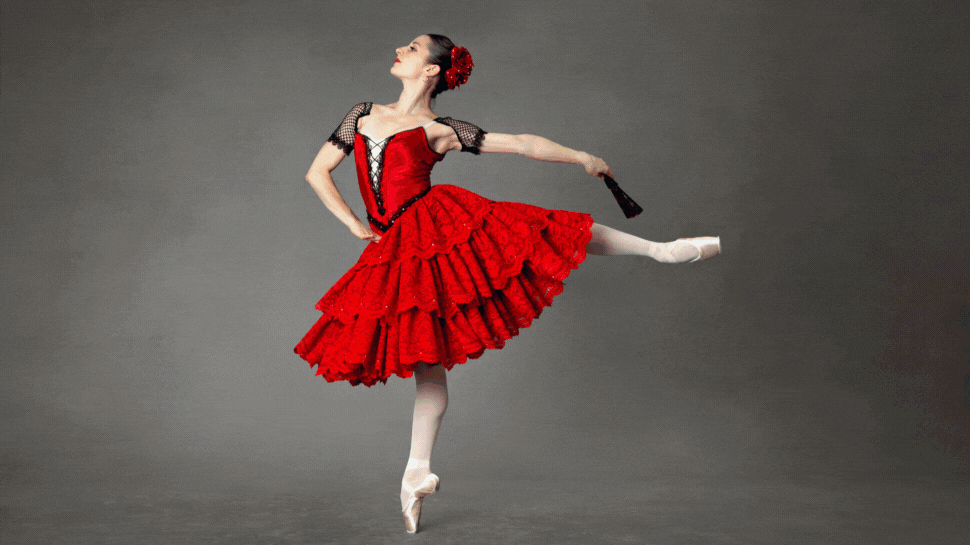 A ballet dancer making a leap against an orange background.