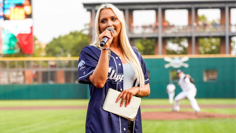 City Editor Hanna talking into a microphone at a Clippers game.
