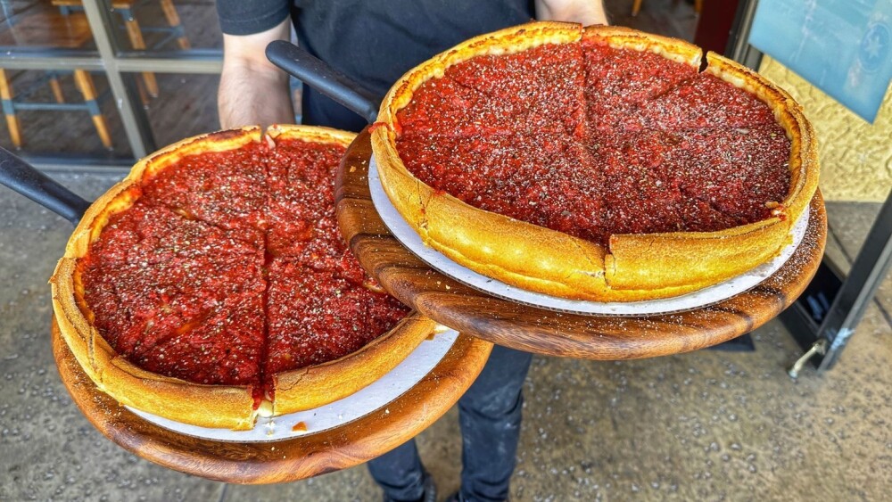 Chicago Bros pizza holding 2 deep dish pies.