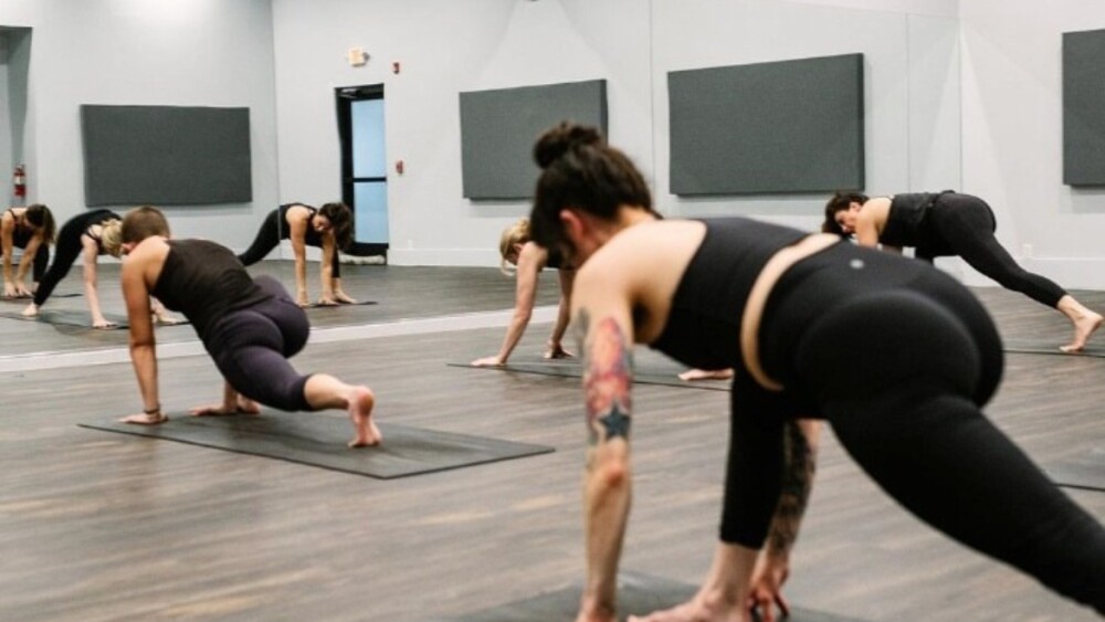 people-dressed-in-black-doing-yoga-poses-on-mats