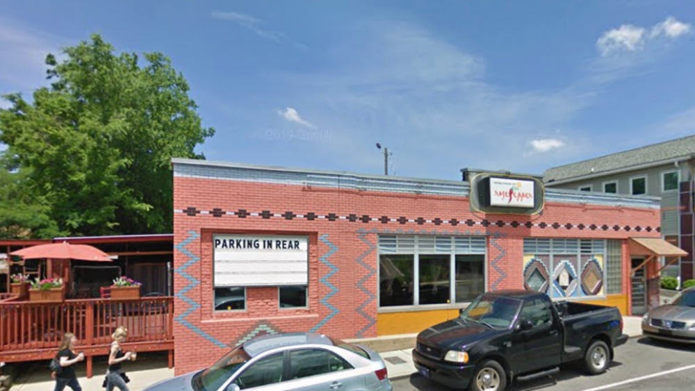 The exterior of Rosepepper Cantina with a side patio, several cars parked out front and a sign reading, "Parking in rear."