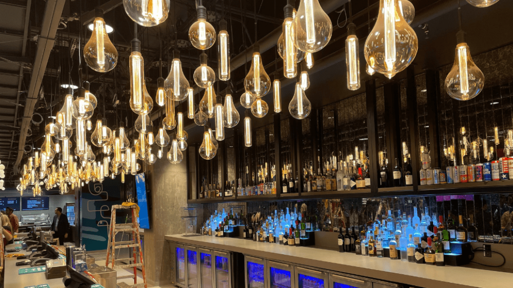 Lights and liquor bottles behind the bar of the Indeed Club at the Moody Center.