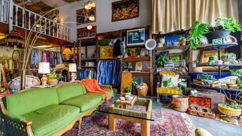 Green couch in a furniture and clothing store.
