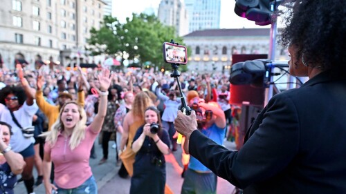 Crowds singing and dancing in front of stage at Donna Summer disco party