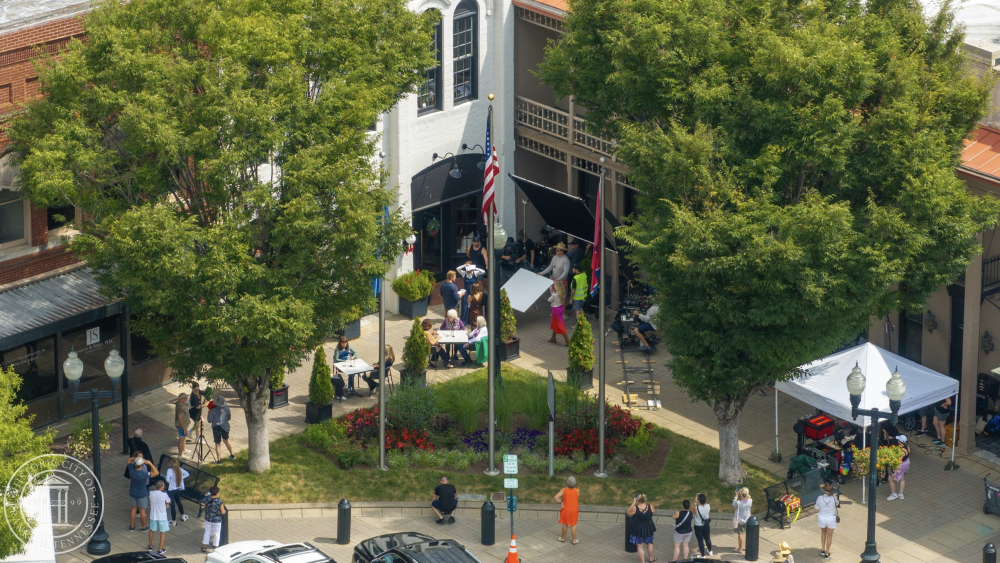 A birds-eye view perspective of a production crew and cast members filming a holiday movie in downtown Franklin, TN.