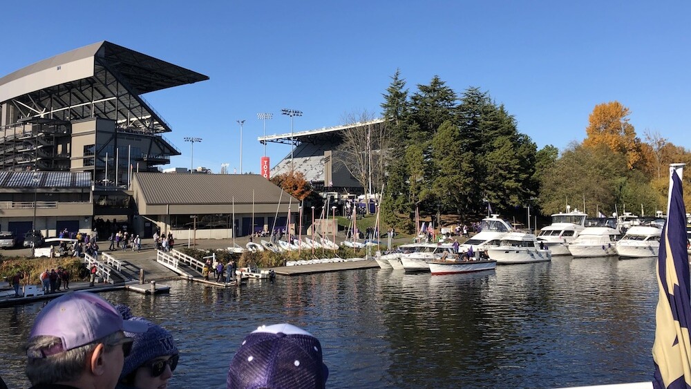 Fans of the UW Huskies look on at Husky Stadium from the nearby docks.