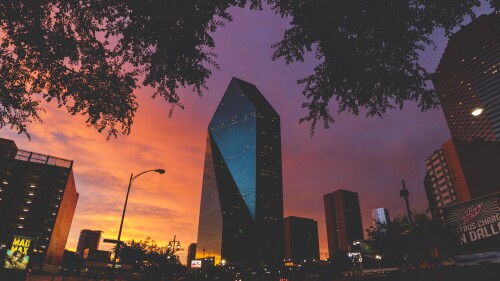Fountain Place Tower with a dramatic yellow and orange sunset in the background.