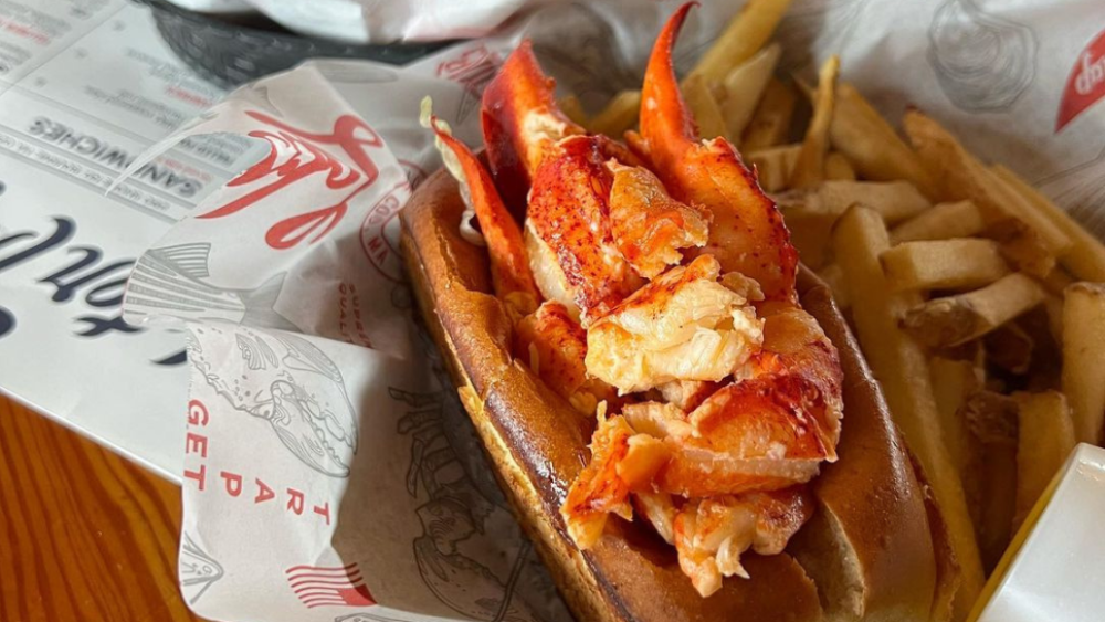 Zoomed in photo of a lobster roll on wooden table at Cape Cod restaurant