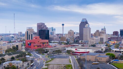 The San Antonio skyline featuring the Tower of the Americas, Central Library, Frost Tower, in a blue, cold hue.
