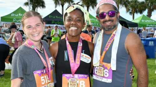 two women and a man in running gear stand side by side at a race