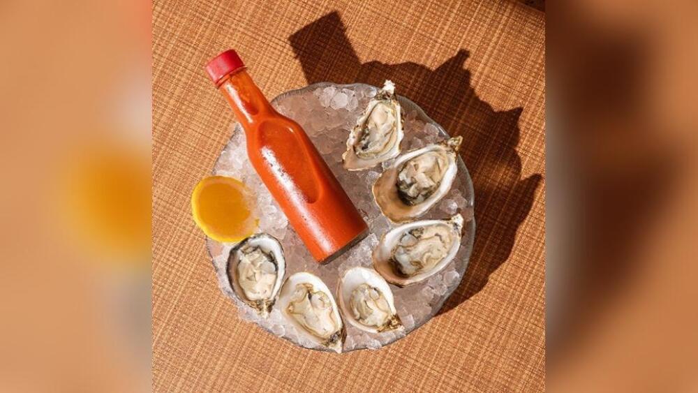 Six oysters on the half shell sit in a bowl with ice and hot sauce at Lazy Susan in Portland, Oregon.
