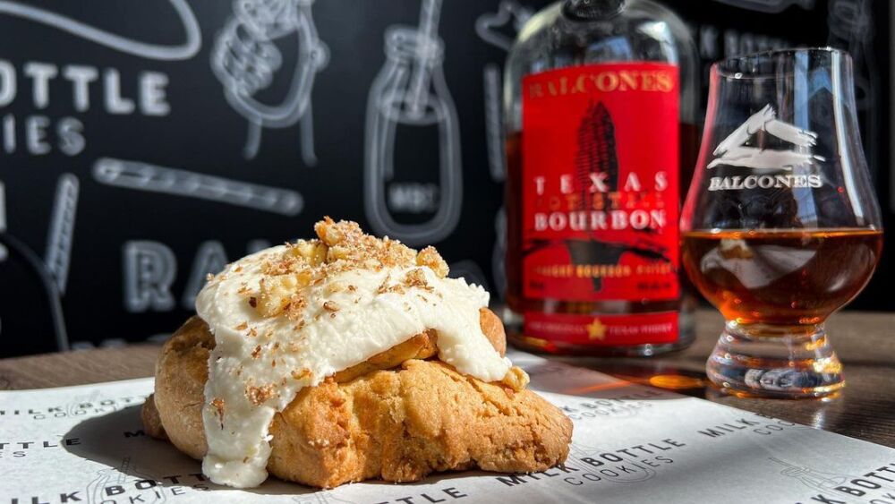 Photo of a cookie next to a whiskey bottle. 