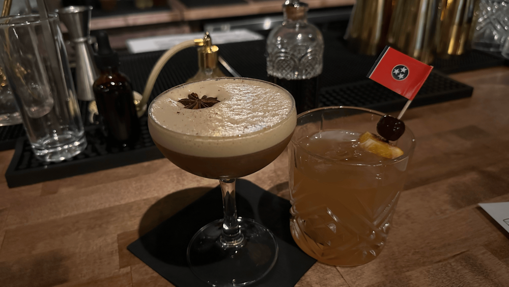 An espresso martini and old fashioned with a Tennessee flag garnish sit on a bar.