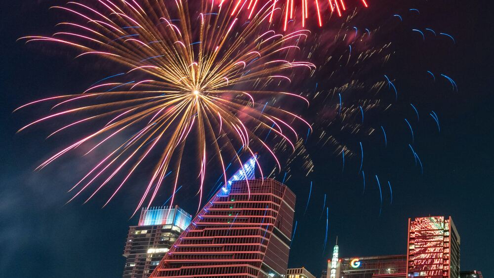 Fireworks exploding over the Google building and other skyscrapers in Downtown Austin.