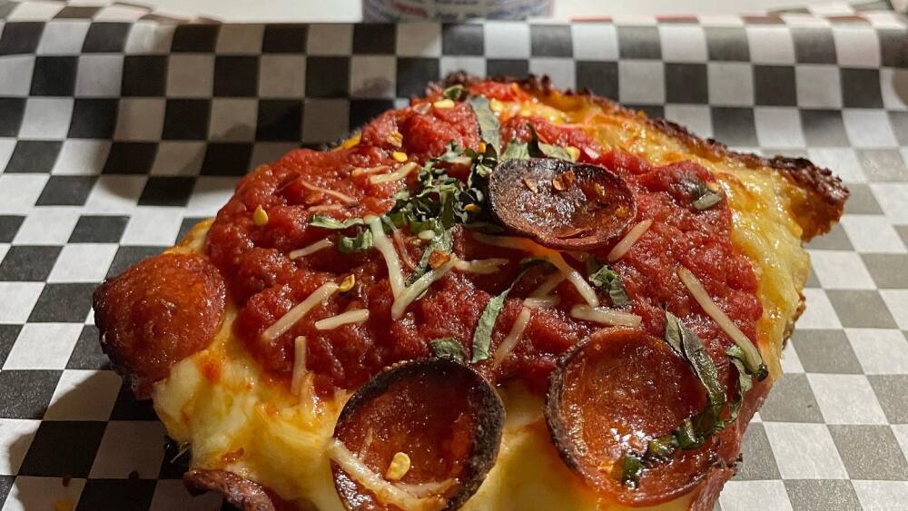 A slice of TnT Pizza's Detroit-style pizza and a PBR.