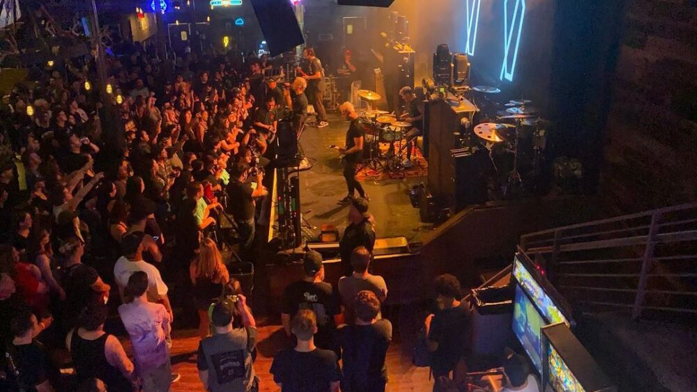 A rock band plays live on stage.