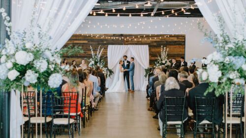 A wedding ceremony with the bride and groom holding hands.
