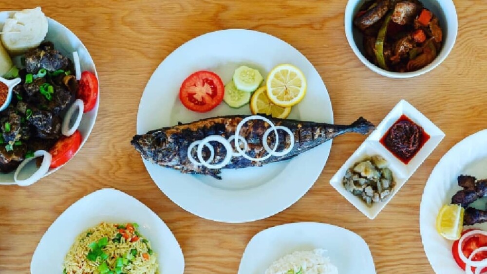 Photos of various Congolese dishes, including a whole grilled fish in the center topped with onions.