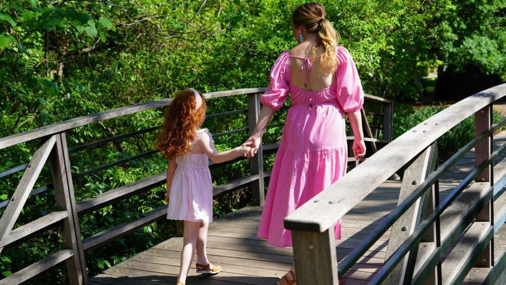 Mother and daughter walking over a bridge at the Botanic Garden.