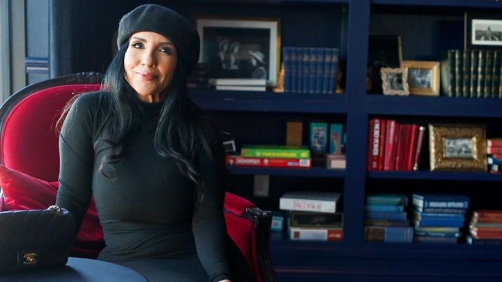 Austin-based influencer Jo poses in front of a bookshelf with a Chanel bag.