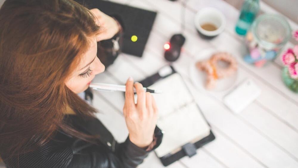 young-woman-thinking-with-pen-while-working-studying-at-her-6384