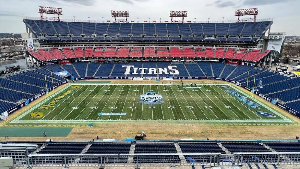 A view of an empty stadium with dark blue and red seats on an overcast day.