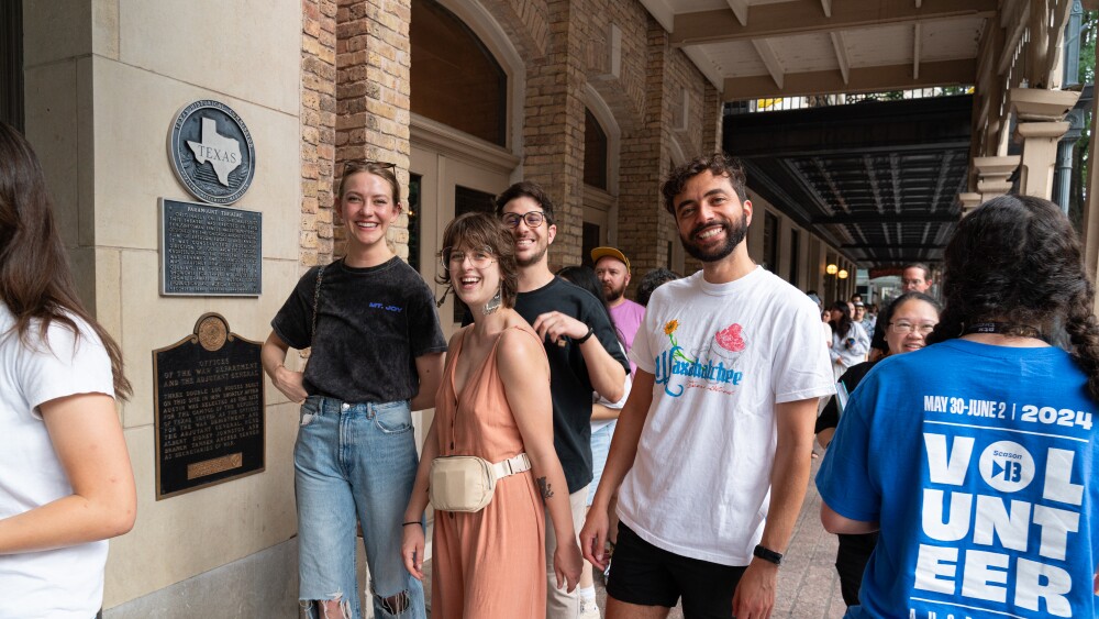 A group of friends smile for a photo in a line outside of the Paramount Theatre in Downtown Austin for ATX TV Festival.