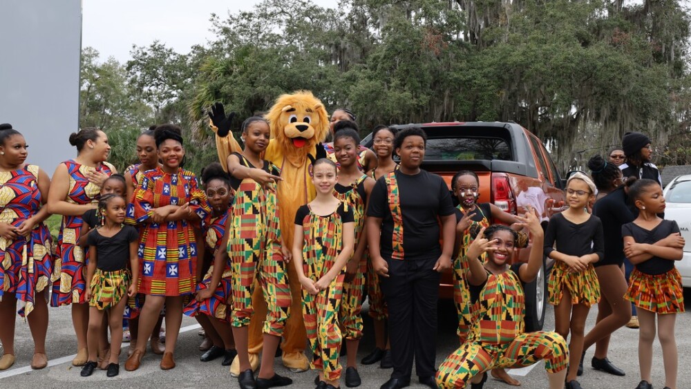 A group of performers dressed in colorful outfits pose at the City of Lakeland's Black History Festival.