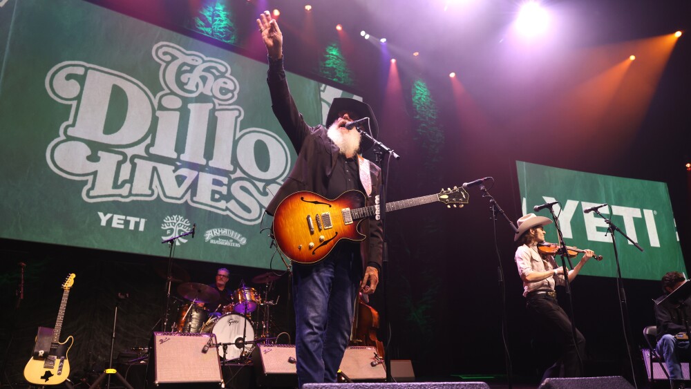 Ray Benson performs in front of a screen reading "The 'Dillo Lives" during the re-launch of Armadillo World at the Austin FC jersey launch party at ACL Live.