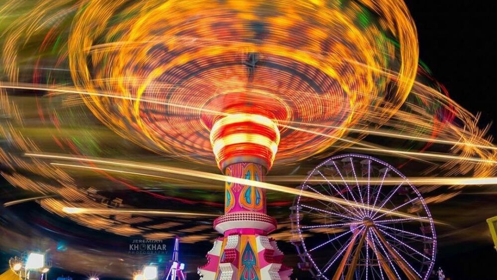 A long-exposure shot of fair rides lit up at night