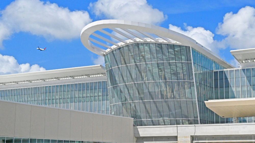 The MCO glass exterior with a plane overhead