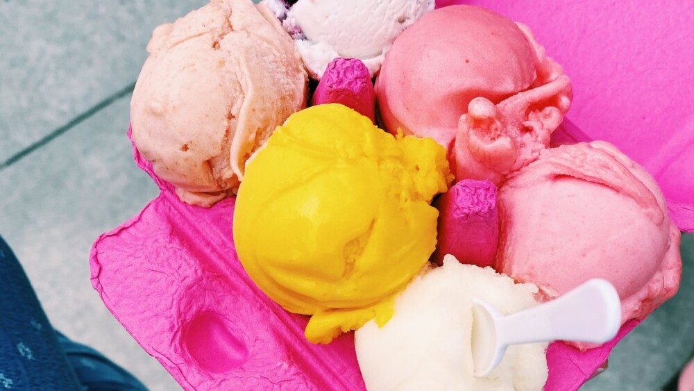 An image of a flight from Ruby Scoops Ice Cream. Six mini scoops of ice cream rest in a pink egg carton.