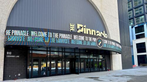 An exterior view of a concert venue (The Pinnacle in Nashville, TN) with a digital marquee that reads "Welcome to The Pinnacle."