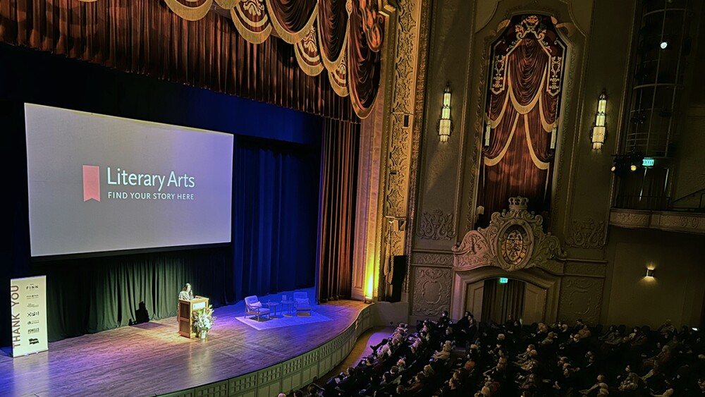 a wide shot of a stage and rows of seating in a theatre