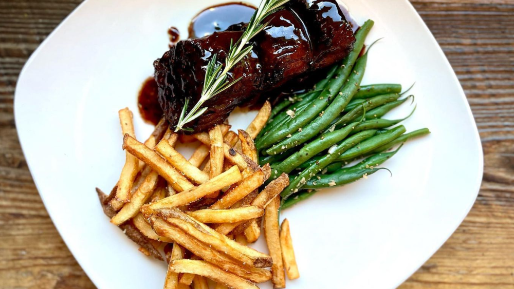 A plate of eggplant steak, garlic green beans, and hand-cut local russet potato fries.