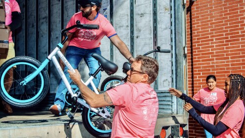 Volunteer lifts blue bike