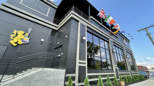 The exterior of a multi-level buildings with flags hanging off the side.