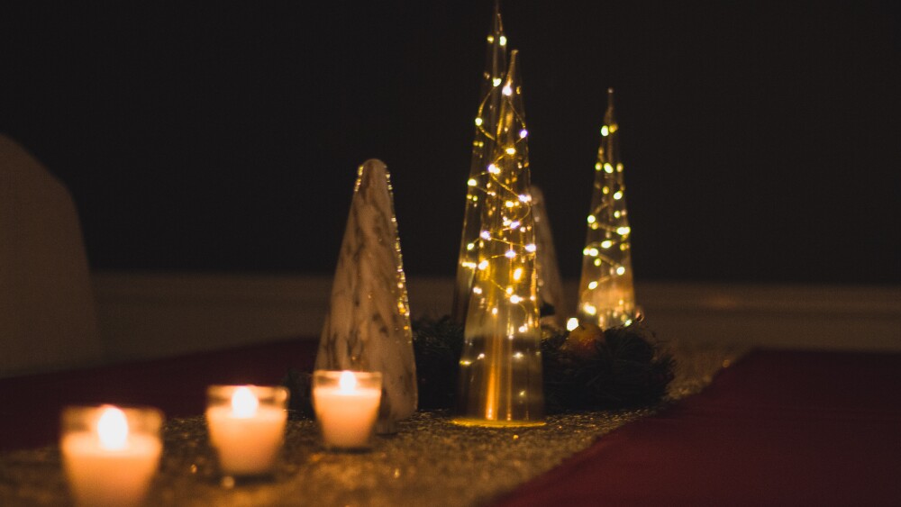 Glass cones are filled with fairy lights as a centerpiece display for a dining table.