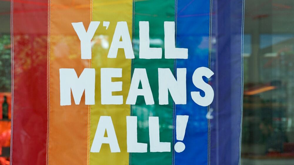 A rainbow flag reading "y'all means all!"