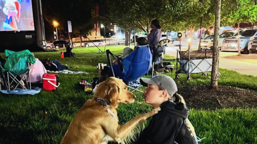 WStoday: pet and his owner sharing a sweet moment during outdoor movie night at Bailey Park