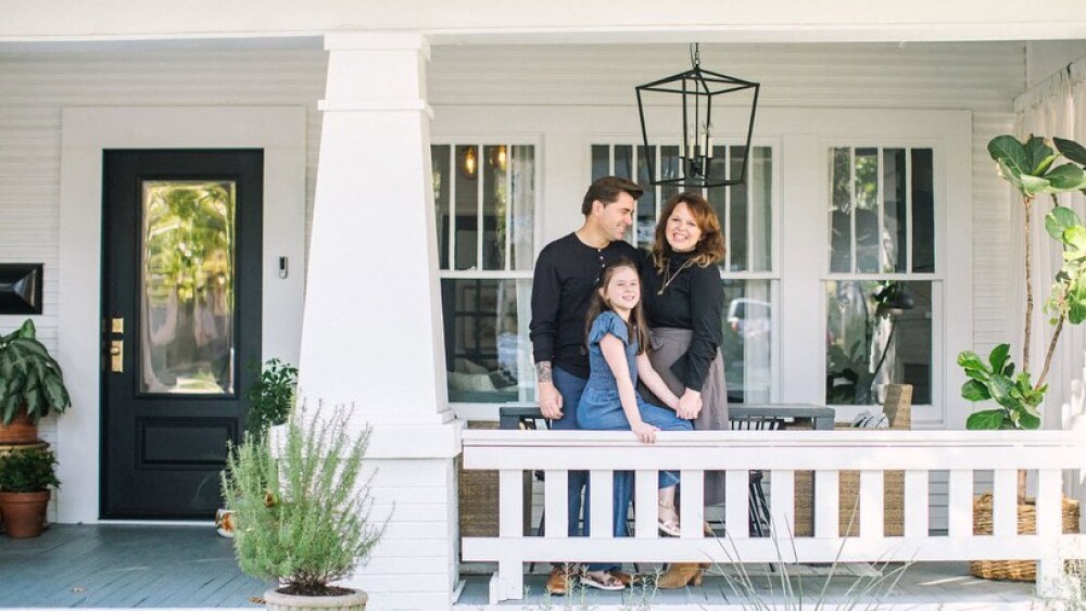 Local wedding planner and designer Lottie of Grit & Gold ©️ poses with her family outside their restored craftsman-style home in Fairmount.