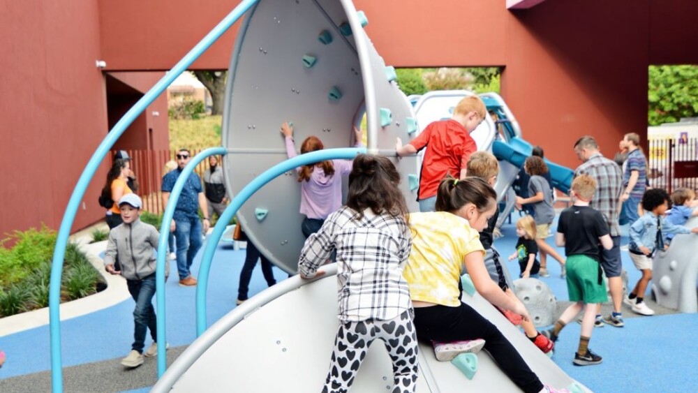 Kids playing on climbing equipment. 