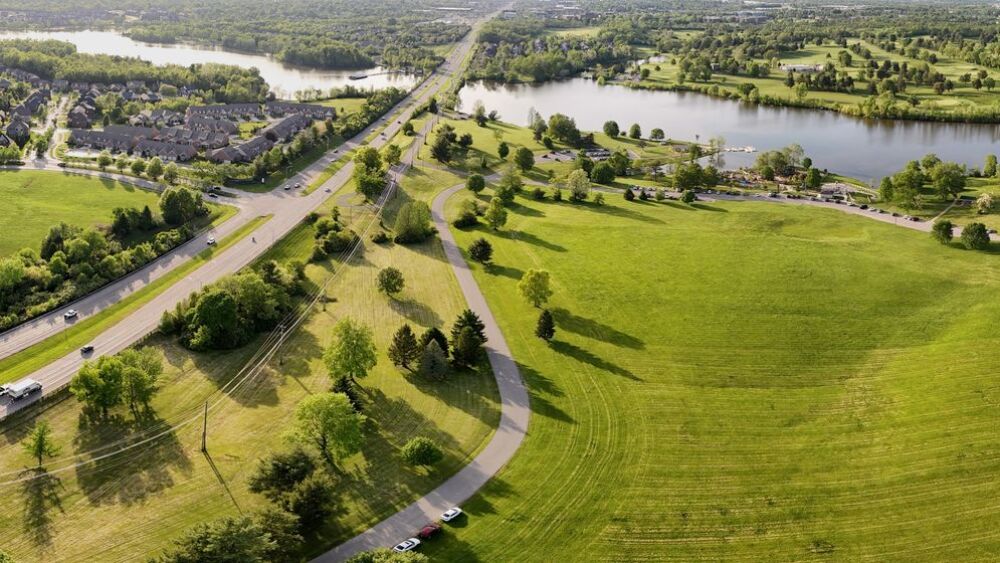 An aerial shot of Jacobson Park with a lake and lots of green space and neighborhoods