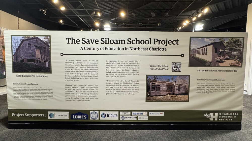 A banner showing the words "Save Siloam School Project," with text and imagery, surrounded by lights.